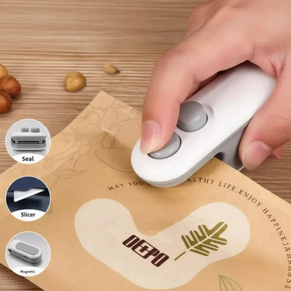 Handheld portable vacuum sealer machine sealing a food storage bag, compact mini heat bag sealer for easy kitchen use
